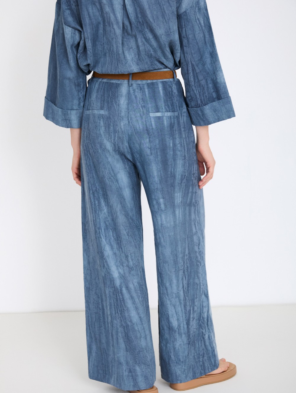 Distressed trousers with pleats