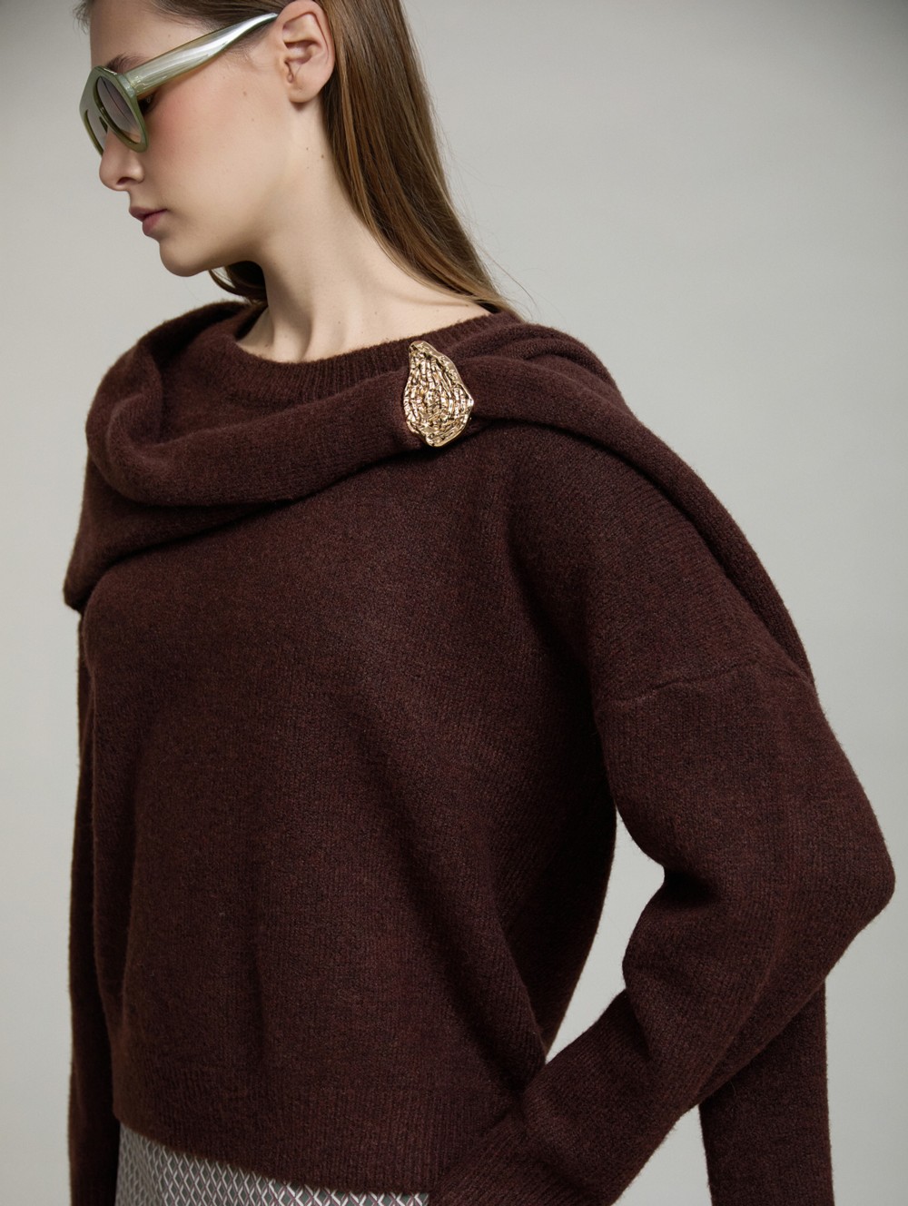 Sweater with gold brooch scarf